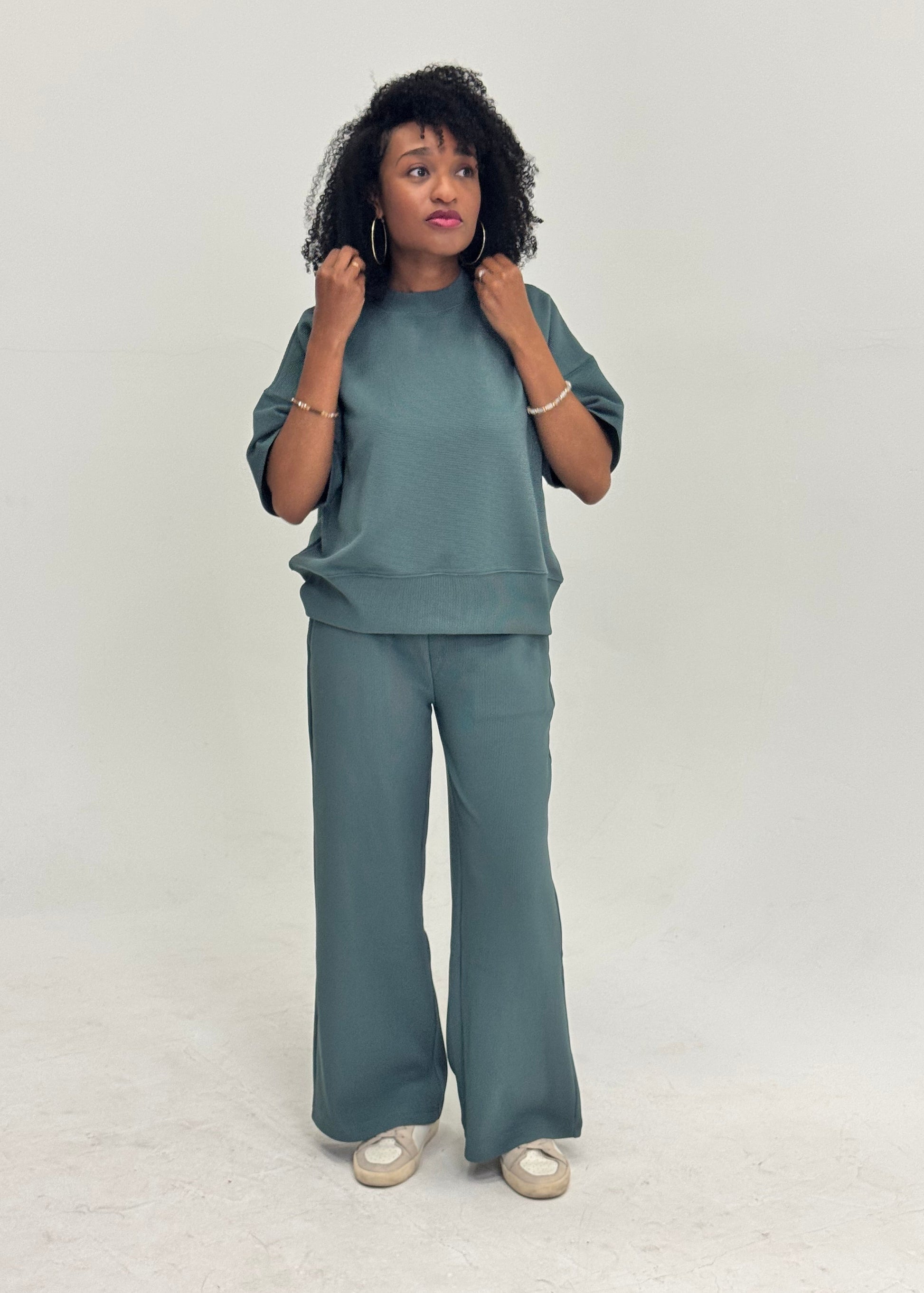 Women wearing a teal outfit on a white background