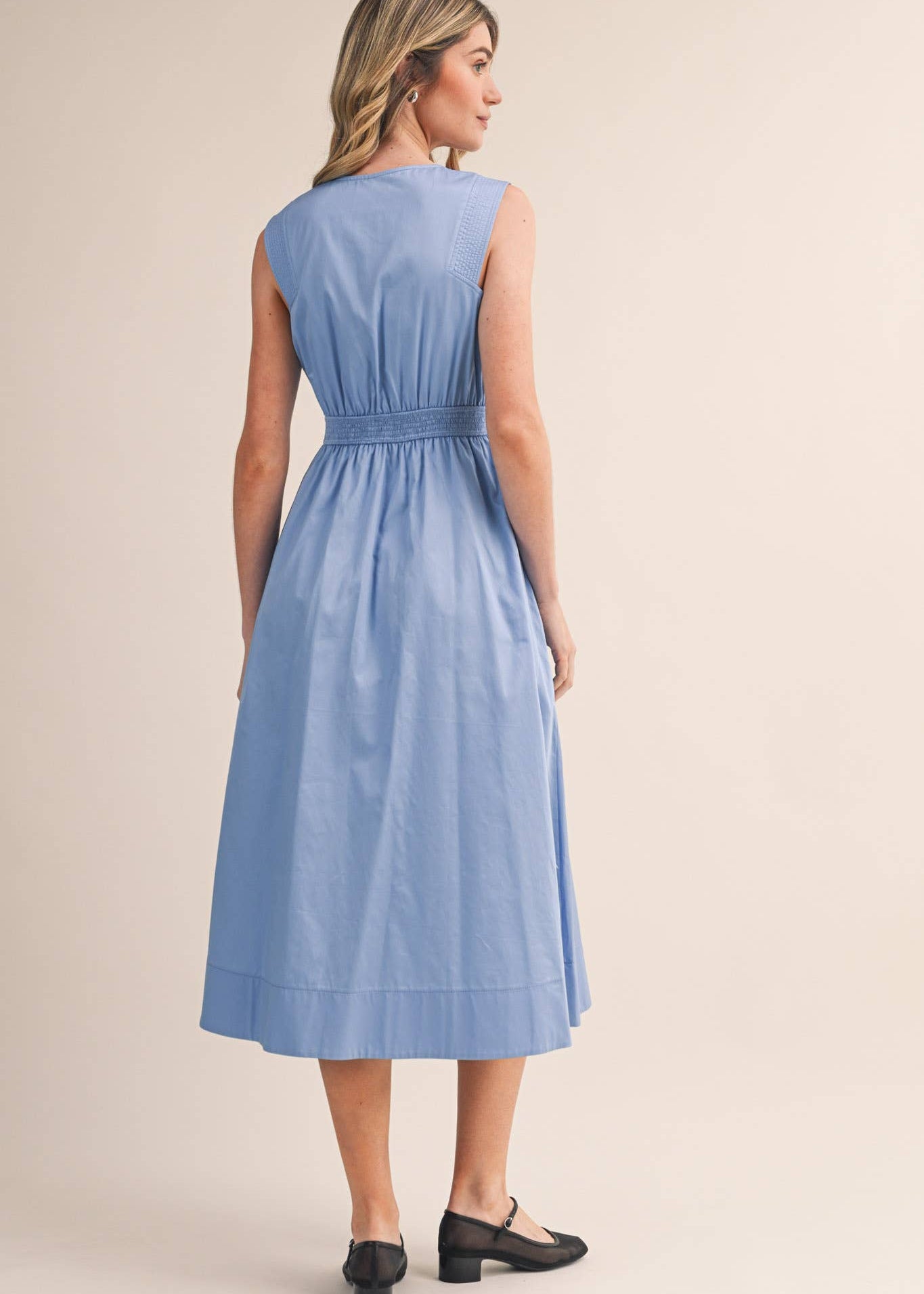 details of back of women sleeve less blue dress 