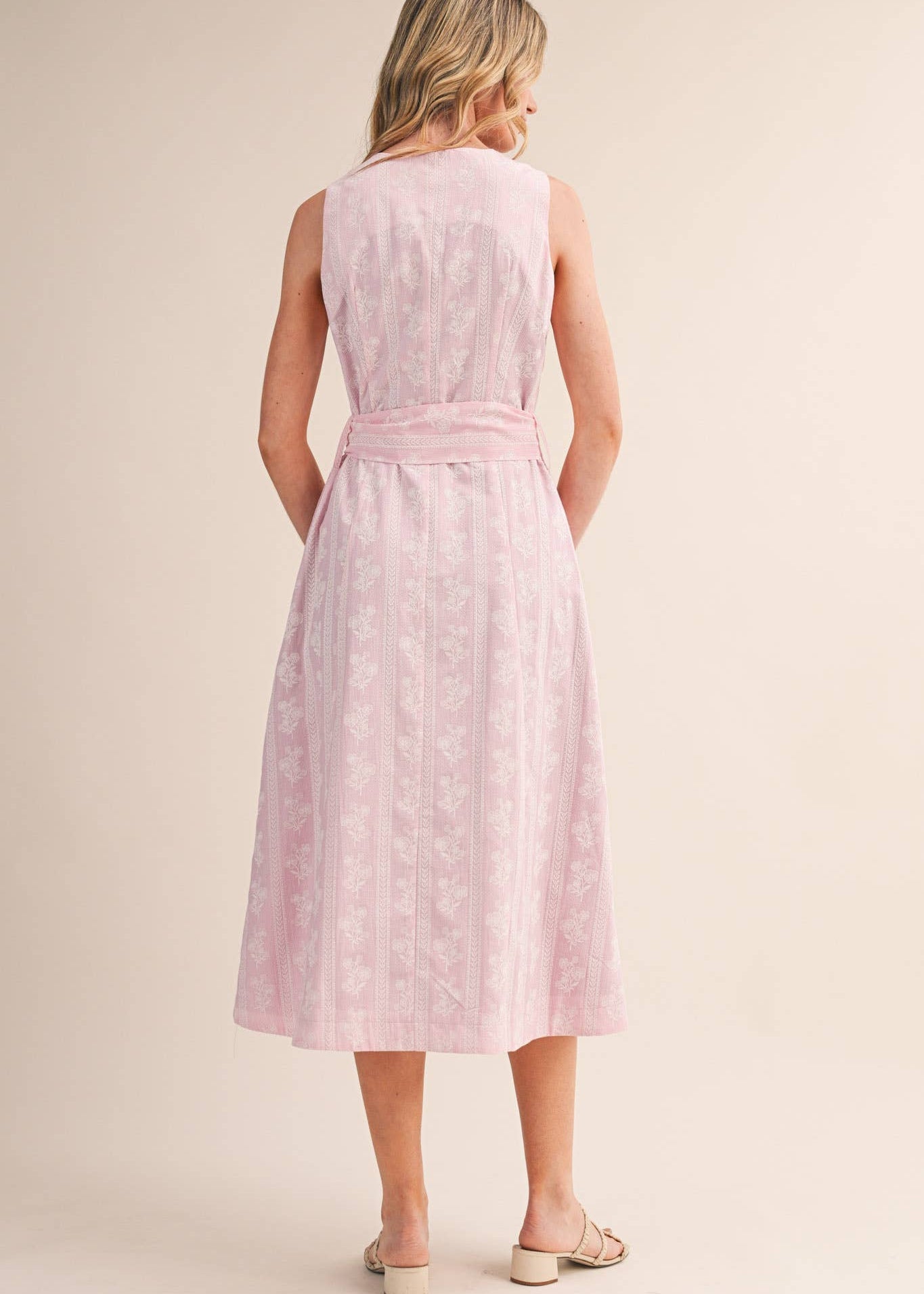 a view of the back of this floral striped pink midi length dress 