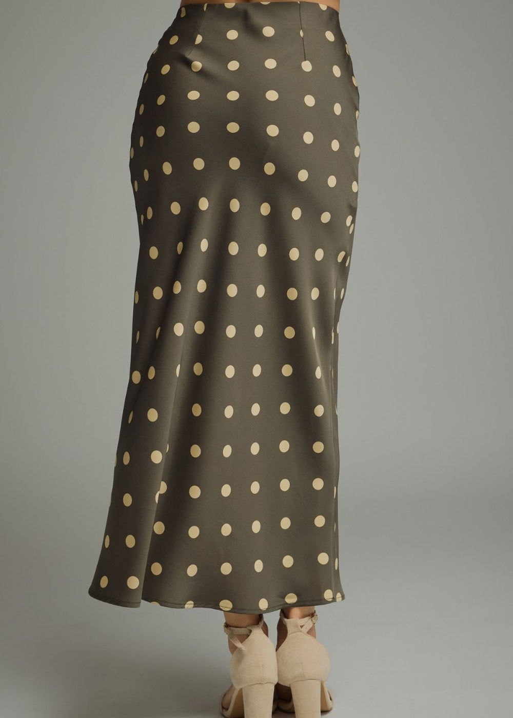 the back of a women wearing a polka dot skirt