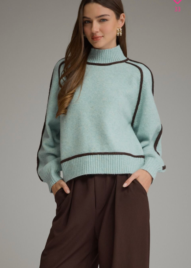 women wearing teal and contrast knit brown trim mock neck balloon sleeve sweater with brown trousers
