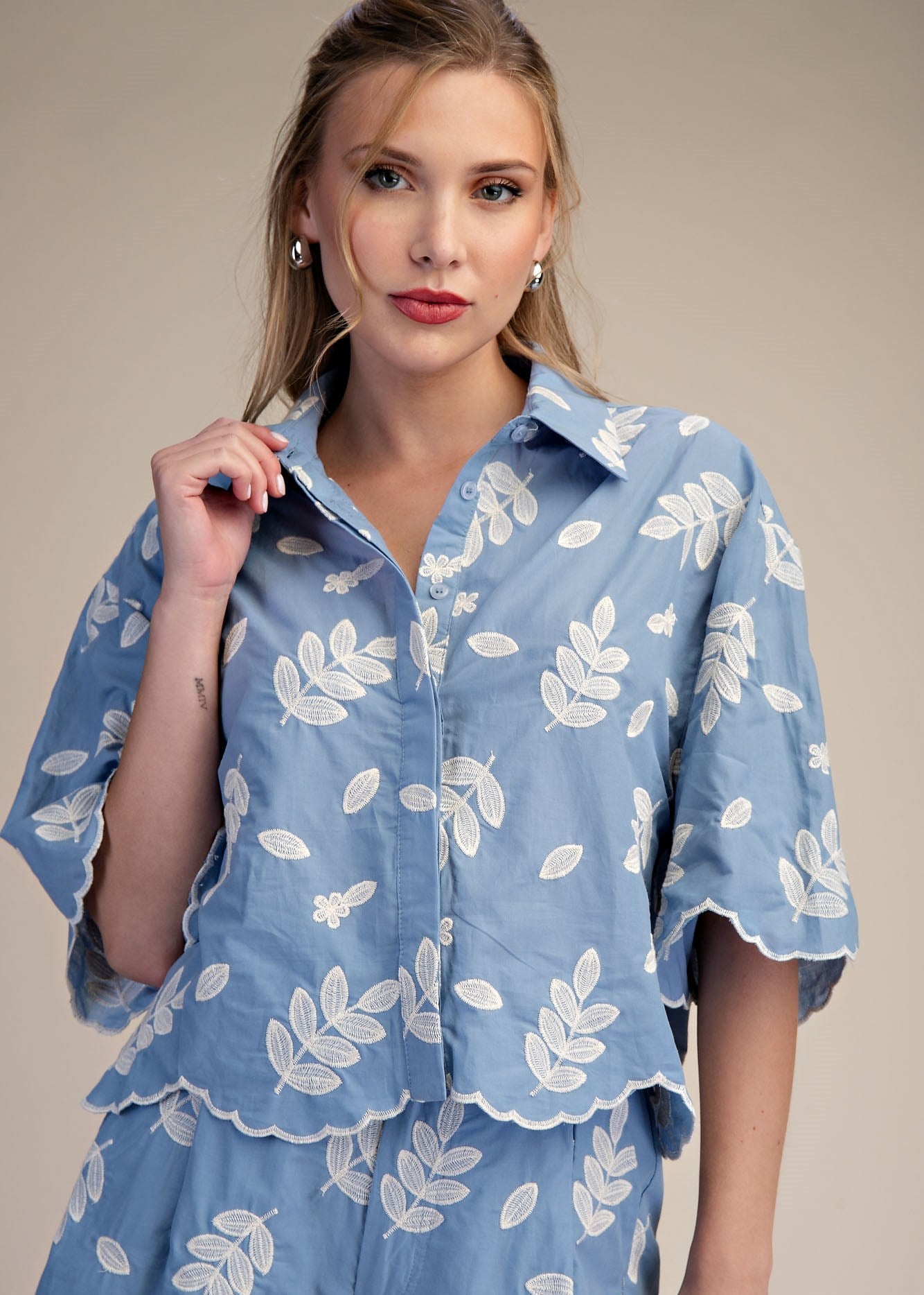 women wearing button down shirt with embroidered details and scallop hem line