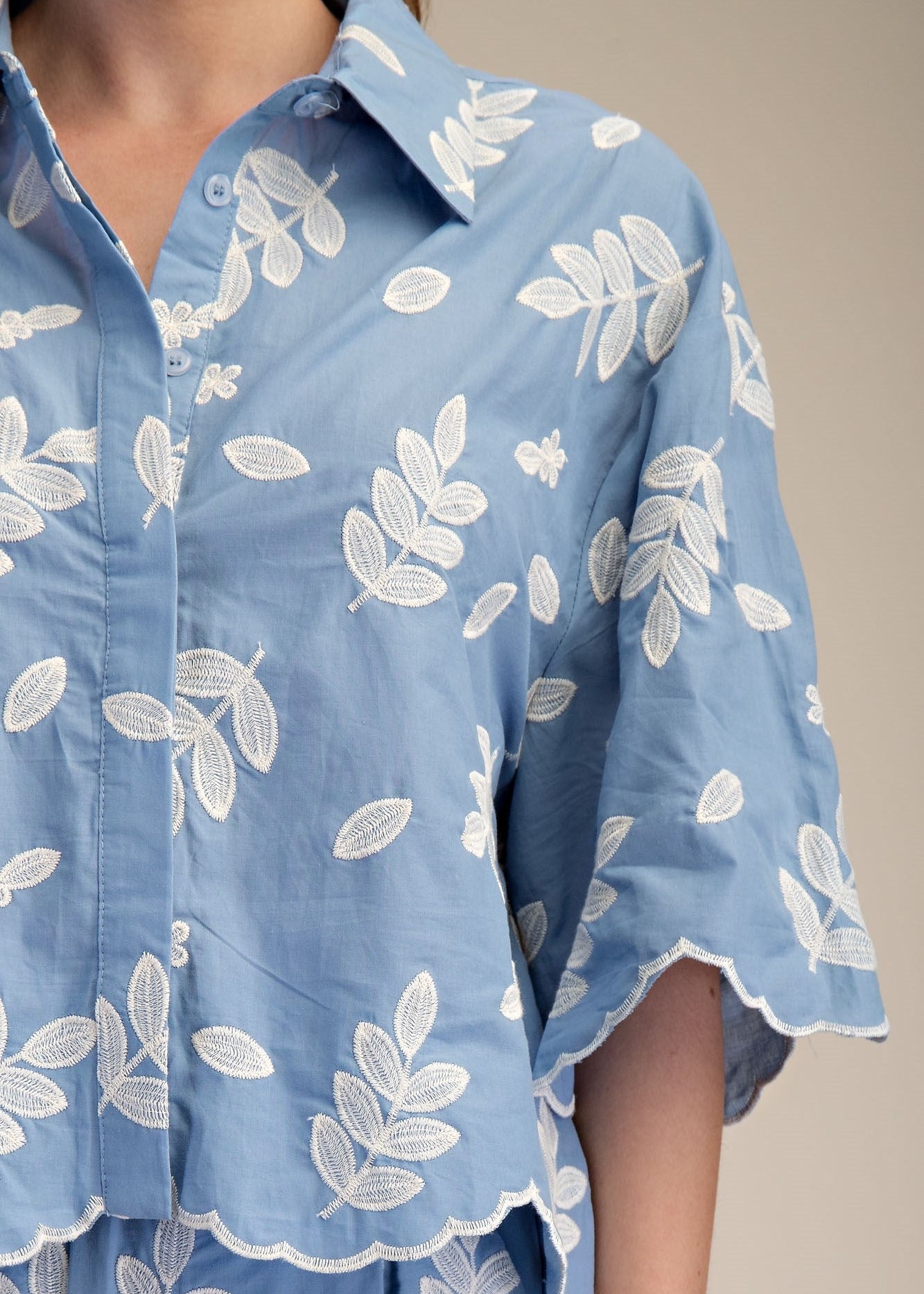 close of embroidered details on blue womens blouse