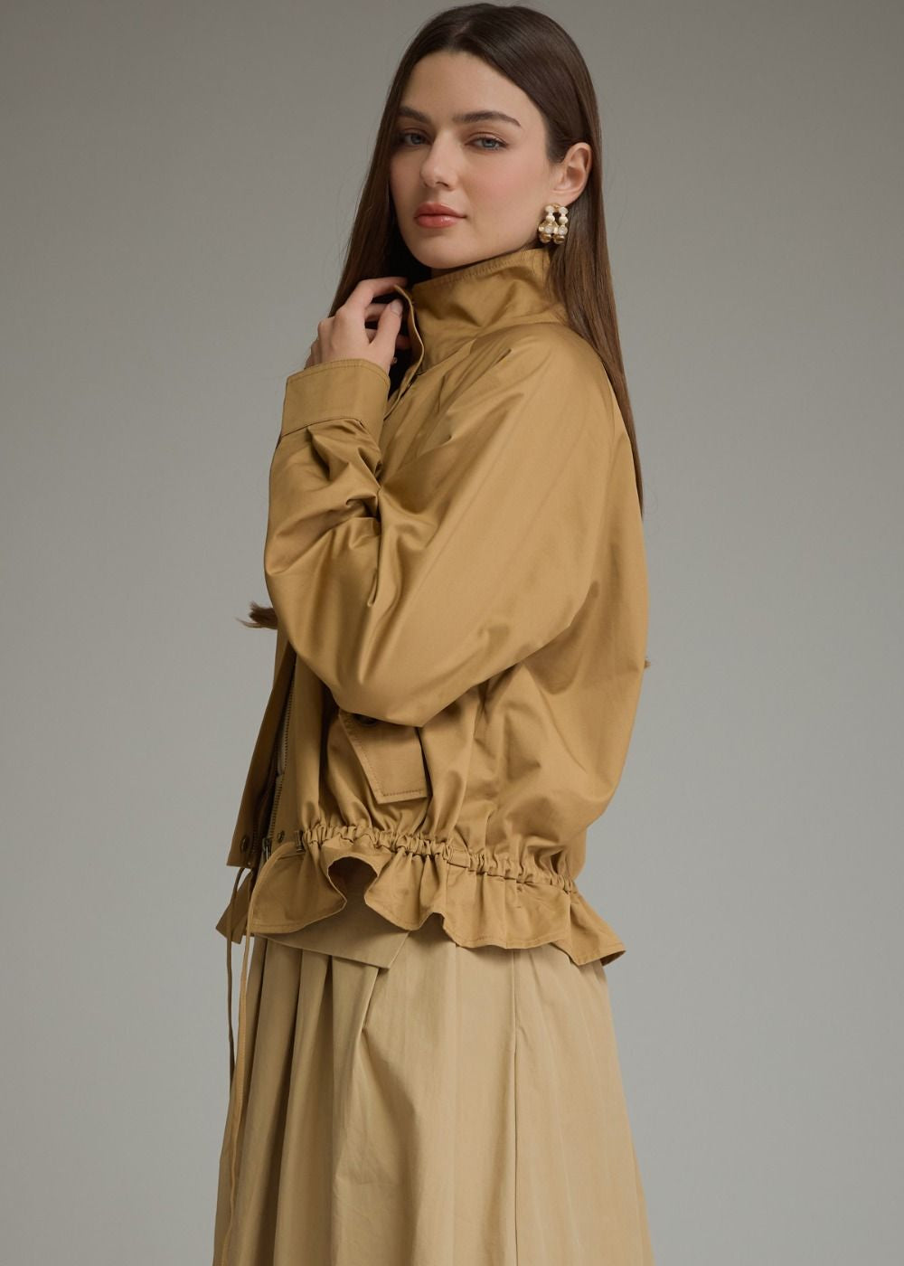 side view of women wearing high neck khaki jackets with a skirt