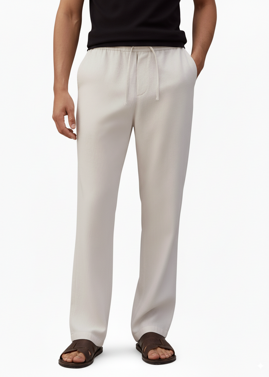 man wearing drawstring pants  with a black shirt and black slides 