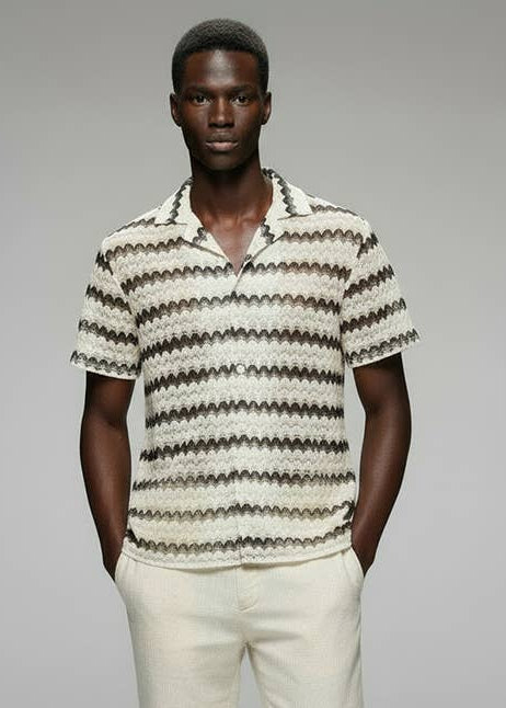 a man wearing a textured stripped collar shirt with short sleeves and linen pants 
