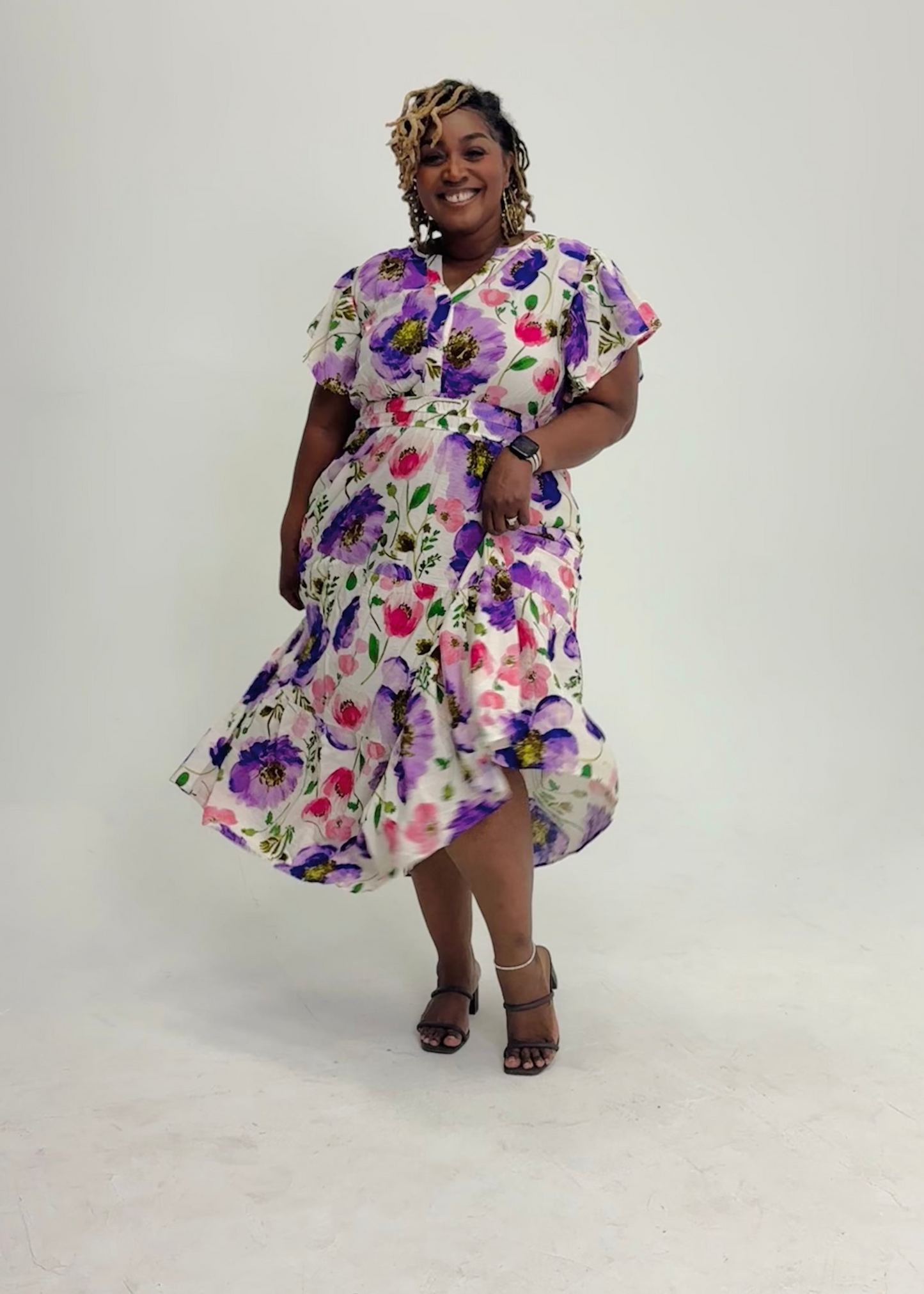 Plus size Woman wearing a floral dress on a white background
