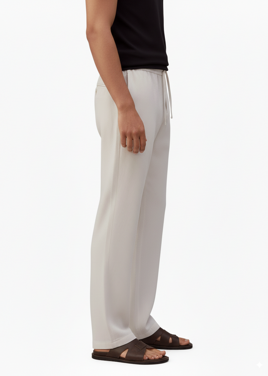 a sideview of man wearing linen drawstring pants with pockets and brown sandals