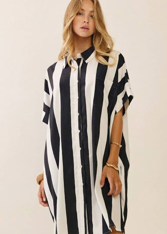 women wearing striped black and white collard dress shirt. Hits above the knee and is short sleeves.