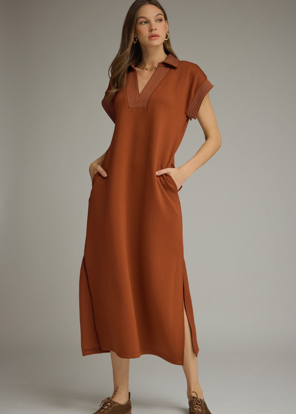 Woman wearing a brown dress with a plain background