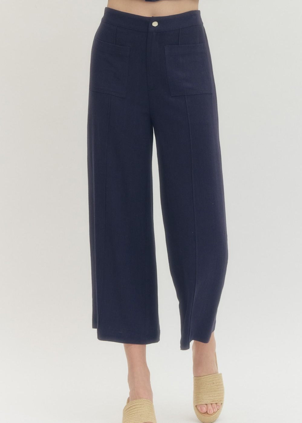 Navy blue pants worn by a person on a white background